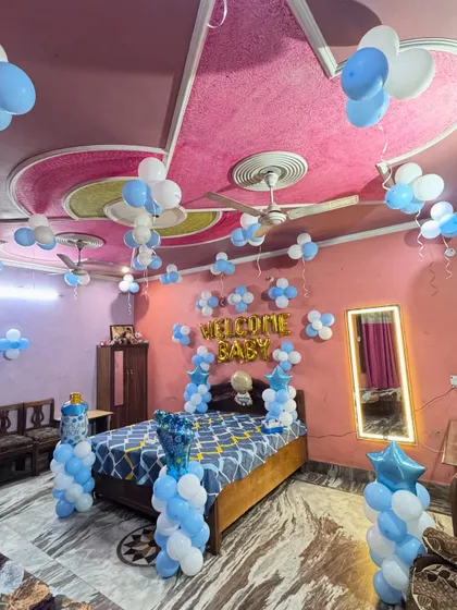 A wide-angle view of the blue and white 'Welcome Baby' room decoration, showing how the entire room is filled with festive balloons.