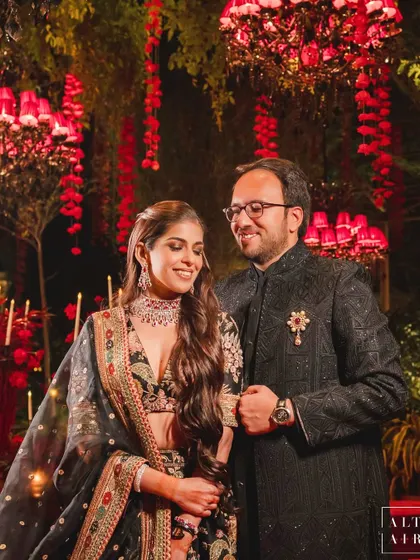 The happy couple at their 'Laal Bagh' reception. The moody, romantic lighting and rich red decor created a perfect setting for their celebration.
