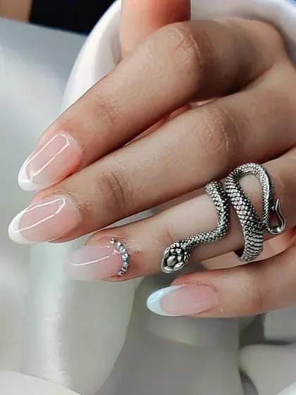 A classy and subtle take on the French manicure, featuring a soft white tip and a delicate rhinestone accent on the ring finger.