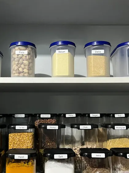 Clear labeling is key to a functional pantry. These containers for staples like pista, besan, and dalia ensure that anyone in the family can find what they need quickly.