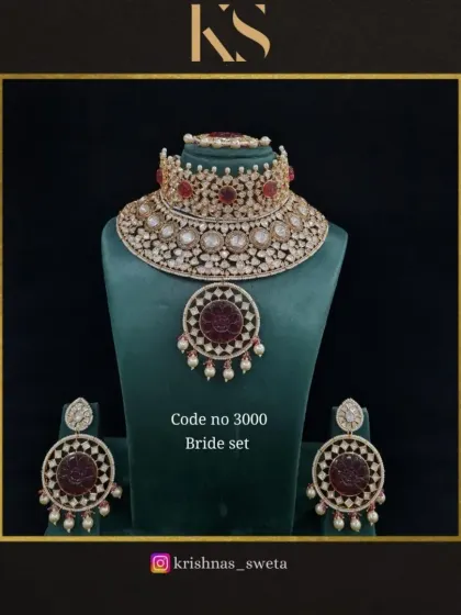 A beautiful Kundan bridal set with a choker and rani haar combination. The intricate coin-like motifs and ruby-colored stones give it a traditional yet unique feel.