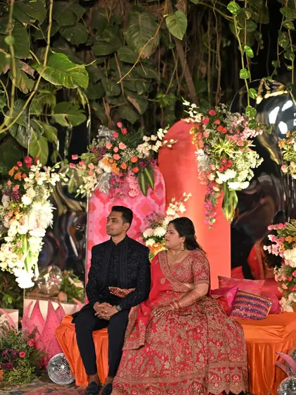 A fun and vibrant Sangeet stage with a disco theme. We used a colorful orange and pink backdrop, floral arrangements, and comfortable seating for the couple to enjoy the performances.