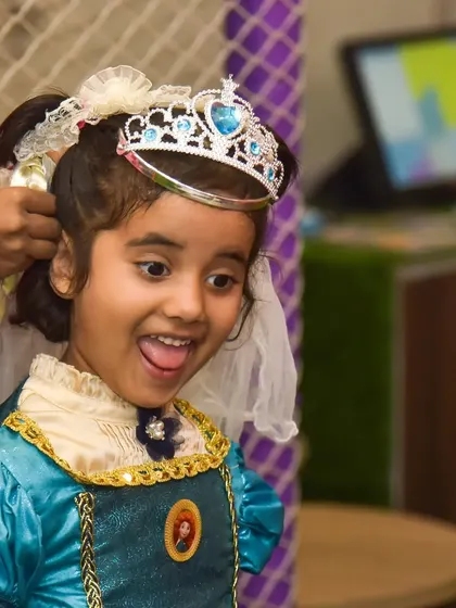 The final touch! A sparkling tiara completes this little girl's princess costume, and her excited expression is priceless.