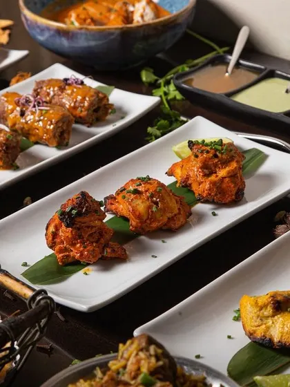 A platter of assorted Indian kebabs, including chicken tikka and seekh kebabs.