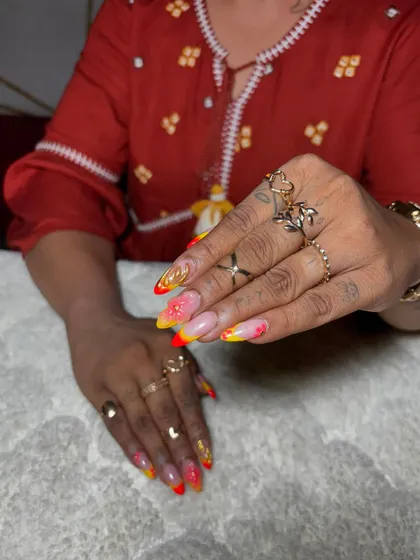 A fiery ombre set with yellow and red tips, accented with gold flakes and 3D elements. This design is for clients who aren't afraid to stand out.