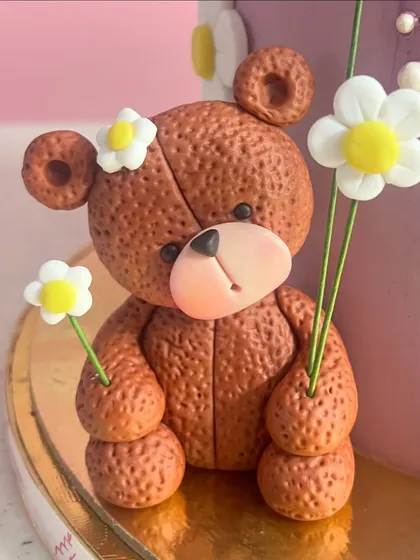 Every detail matters. This little fondant teddy bear, holding a daisy, adds so much character to the side of the cake. It's these small touches that create a memorable design.