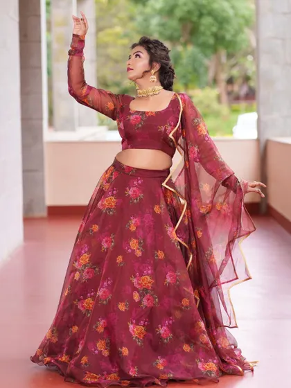 A graceful pose in the maroon floral lehenga, showing the movement of the lightweight organza fabric.