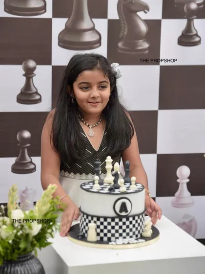 A close-up of the birthday girl enjoying her chess-themed cake. Our decor creates a cohesive and elegant atmosphere for any celebration.