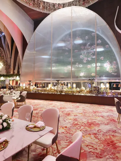 Our buffet stations are designed to be architectural elements within the event space. Here, a grand arched window frames our extensive spread, creating a stunning focal point for guests.