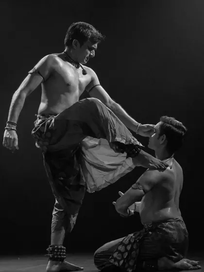 A black and white shot from 'ATAH' that captures a moment of tension and power. The physicality of the performance is central to its storytelling.