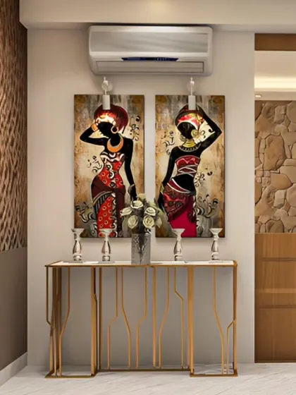 An entryway that showcases personal style with African-inspired artwork. The slim, gold-legged console table provides a surface for decor without taking up much space in the hallway.
