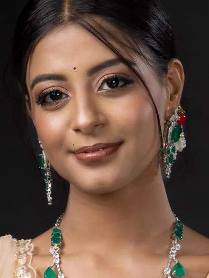 A clean and simple beauty headshot, focusing on the model's smile and jewellery.