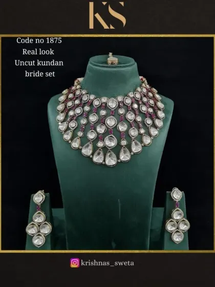 This real-look uncut Kundan set is accented with deep ruby red stones, adding a touch of classic bridal color to the design.