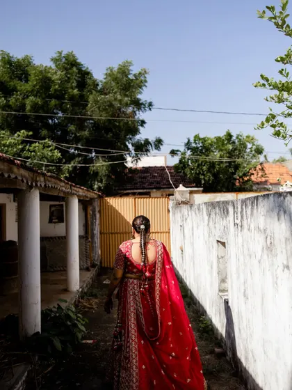 A view of the bride's complete look from the back, highlighting the elegant drape of her dupatta and the detailed braid.