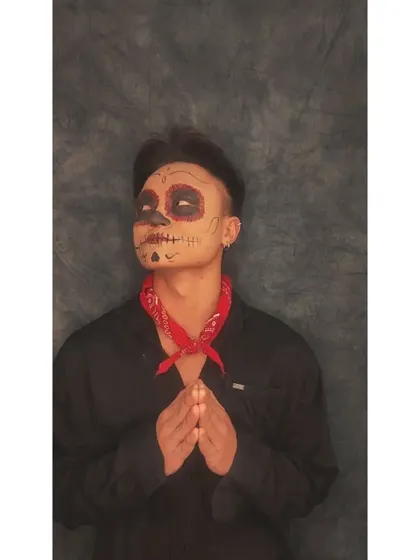 Another angle of the sugar skull look, showing how the design wraps around the facial structure. The red bandana adds a pop of color that complements the makeup.
