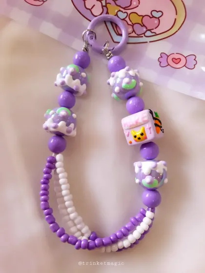 A detailed shot of the purple cake-bead charm, highlighting the cute Pikachu-like character bead in the center.