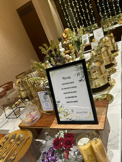 An elegant buffet setup for a house party, featuring our signature gold chafing dishes and a clearly displayed menu. We handle every detail, including the presentation, so you can focus on enjoying the moment with your guests.