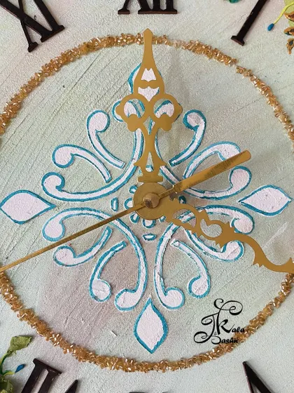 A close-up of the elegant stencil work and golden hands on the 14-inch neutral-toned wall clock.