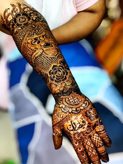 A side view of the matured henna stain, showing the detail on the forearm. The design includes classic floral and paisley elements.