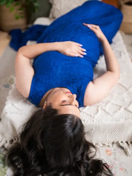 An artistic overhead shot that emphasizes the beautiful shape of pregnancy. This perspective offers a unique and intimate view, focusing on the mother-to-be in a moment of quiet reflection.
