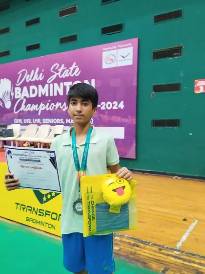Kartik proudly displaying his two silver medals from the Delhi State Championships in the Under 13 boys' singles and doubles categories. A fantastic double achievement.