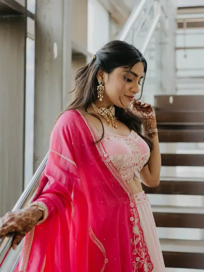 A candid moment on the stairs, showing off the soft and dreamy engagement makeup. The half-tied hair with gentle curls adds a touch of effortless elegance to the overall look.