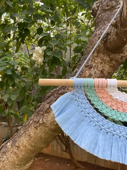 A close-up of the rainbow tapestry, showing the different knotting techniques used to create the colorful arcs and the soft, fringed bottom layer.