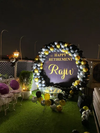 A wide shot of the rooftop retirement party, showing the seating arrangement.