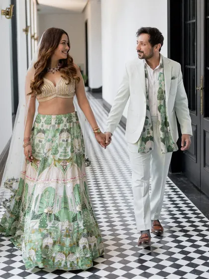 The happy couple walks hand-in-hand down a stylish checkered hallway after their engagement, their coordinated outfits looking fresh and modern.