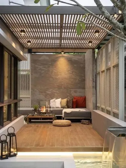 This patio design features a small waterfall that flows into a channel alongside the seating area. The sound of water adds a calming element to this beautiful outdoor space.