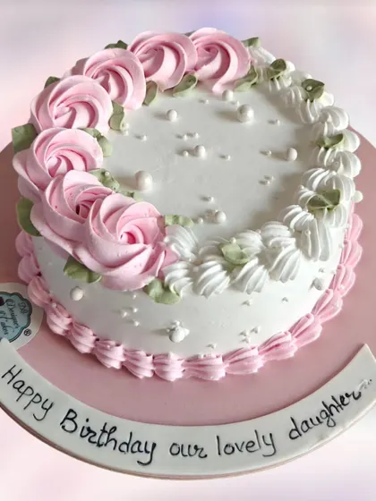 A simple and classic floral cake with pink rosettes. This timeless design is perfect for any daughter's birthday.