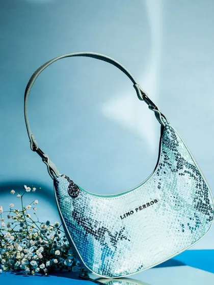Here, I captured a single shoulder bag with a floating effect to give it a sense of lightness and elegance. The simple prop of baby's breath flowers adds a delicate touch to the modern, edgy snakeskin texture.