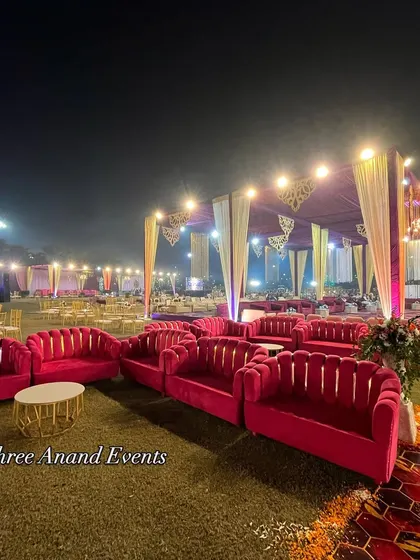 Bright pink lounge sofas arranged on the lawn, providing a pop of color and a comfortable space for guests to enjoy the evening.