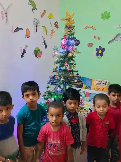 Our boys looking festive next to the Christmas tree. We ensure every child feels included in our diverse cultural celebrations throughout the year.