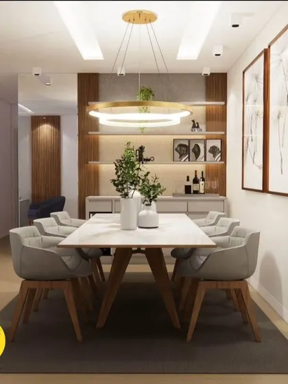 A front-on view of the dining setup, highlighting the statement ring chandelier and the elegant, modern dining chairs.