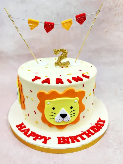 We celebrate a little cub's birthday with this cheerful cartoon lion cake. A friendly lion face, festive bunting, and a glittering number "2" candle make this a bold and playful centerpiece for a jungle-themed party.