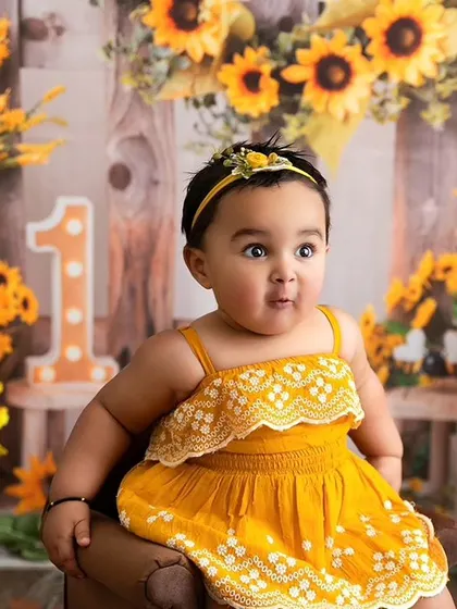 A funny and adorable expression captured during the sunflower session, showing the playful side of baby photography.