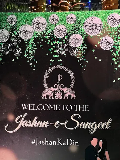 A welcome sign for the 'Jashn-e-Sangeet'. The design, featuring disco balls and the couple's monogram, perfectly matches the glamorous and celebratory theme of the night.