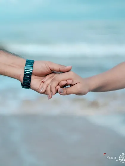 A simple, beautiful close-up of the couple holding hands with the ocean in the background. Sometimes the smallest details tell the biggest story of connection.