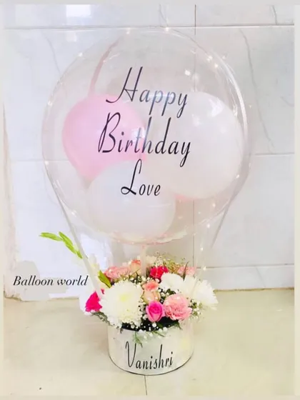 A lovely birthday hamper featuring a personalized box and balloon. The arrangement is filled with fresh roses and carnations, creating a beautiful mix of textures and colors.