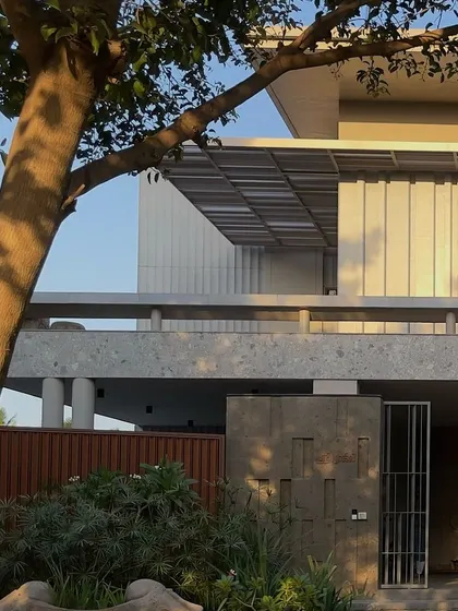 The warm evening light catches the textured facade of 'STILL HOME'. The interplay of solid and void, light and shadow, and hardscape and softscape creates a dynamic yet calming exterior.