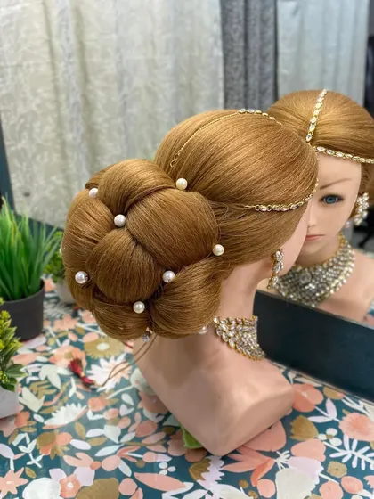 The reflection in the mirror shows the perfect symmetry of the 3D braided bun. I emphasize precision and neatness in all the techniques I teach.