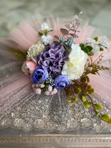 Themed trousseau packaging, featuring a beautifully embellished saree wrapped in sparkling pink tulle and topped with a floral arrangement.