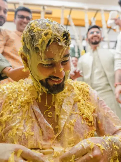 The aftermath of the Haldi madness. The groom is completely covered in turmeric paste, a testament to a ceremony filled with enthusiastic friends and family.