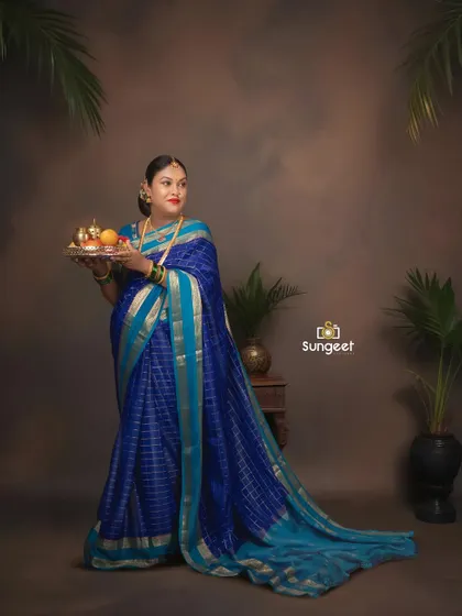 Holding a traditional thali, this mom-to-be looks radiant. We use props to add cultural significance to our saree maternity photoshoots.