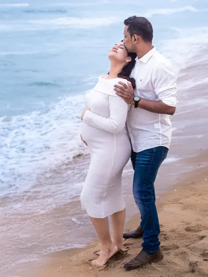 An intimate embrace by the sea. This pose beautifully showcases the baby bump while highlighting the couple's connection.