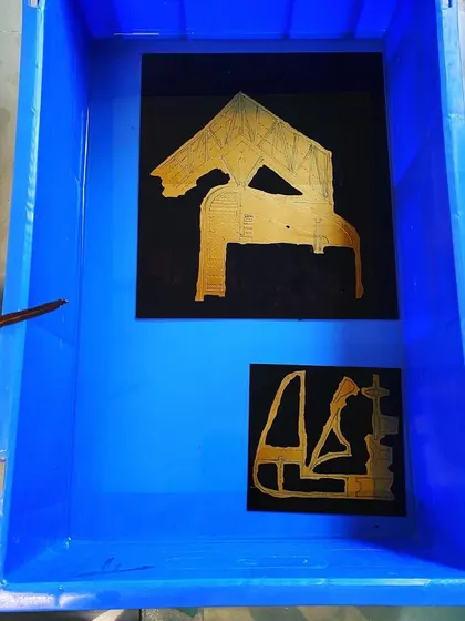 Etched plates submerged in a ferric chloride bath. This alchemical part of the printmaking process, where acid bites into the metal to create the image, is a powerful metaphor for how ideas are given permanent form.