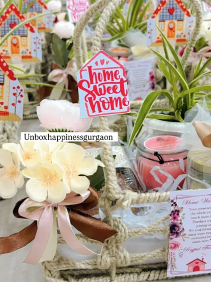 This detailed shot highlights the contents of a housewarming favor, including a small plant, a scented candle, and a beautifully tied ribbon.