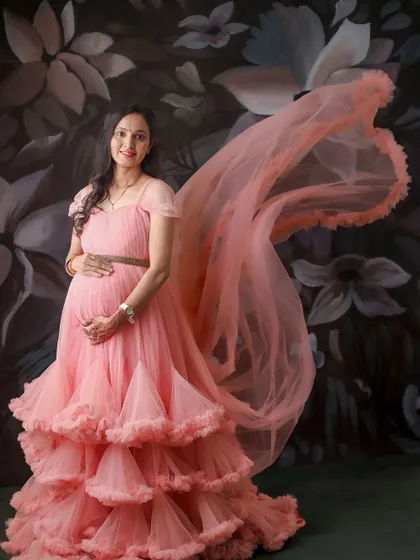 The flowing fabric of this pink gown creates a beautiful sense of motion. This portrait is taken against one of our custom-painted, artistic backdrops.