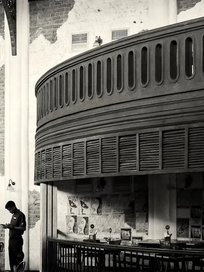 The massive, curved balcony structure overhangs a smaller bar area below, showcasing the complex, multi-level design.